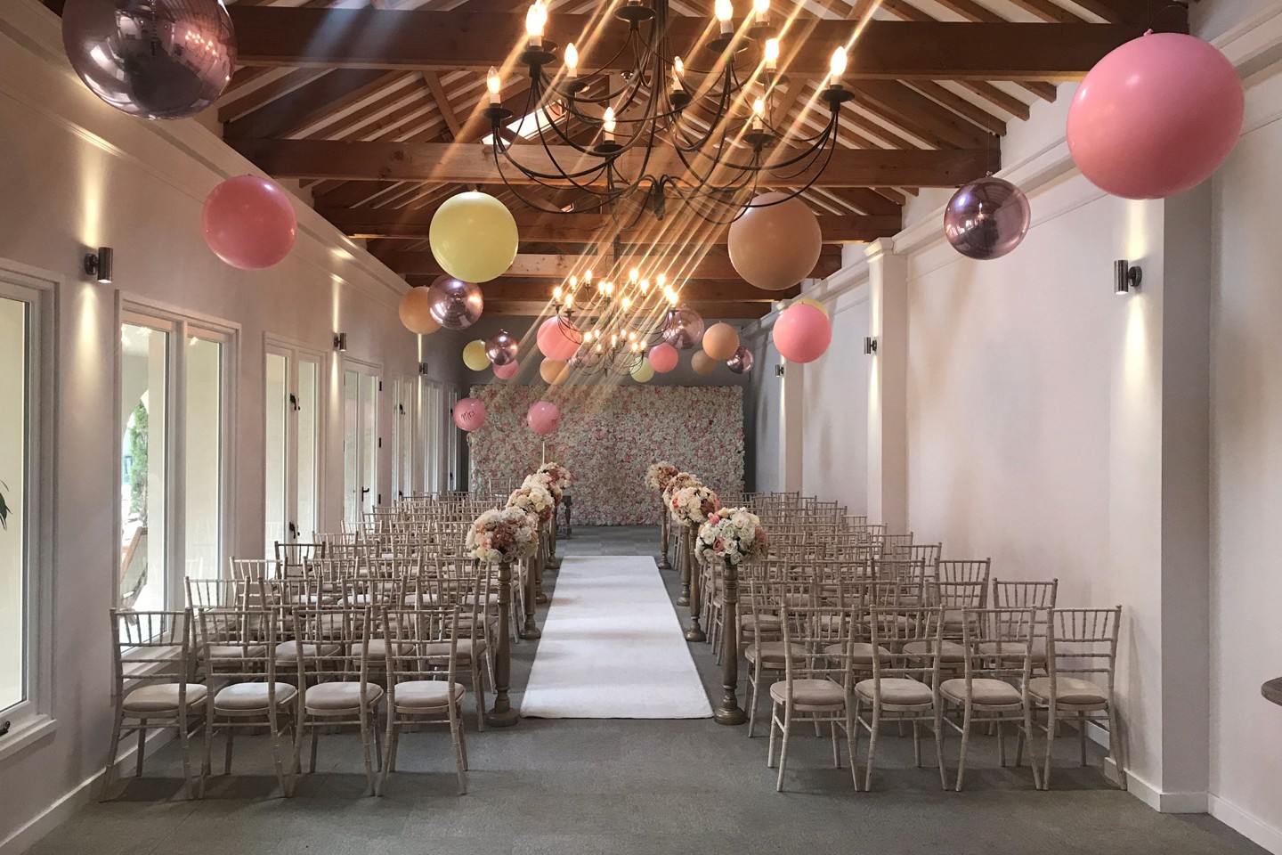 Cloisters set up for a wedding ceremony with a flower wall